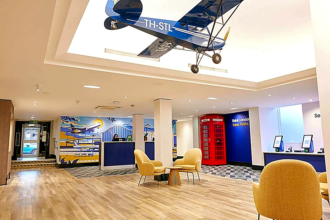 Aviation-themed hotel lobby with reception counters and lounge seating