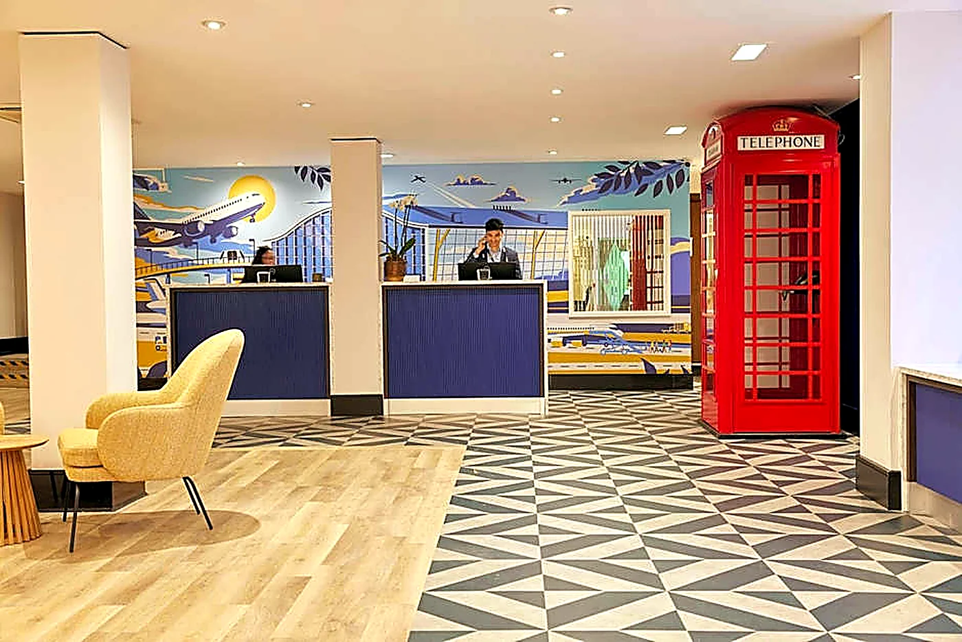 Aviation-themed reception space with patterned flooring and feature red telephone box