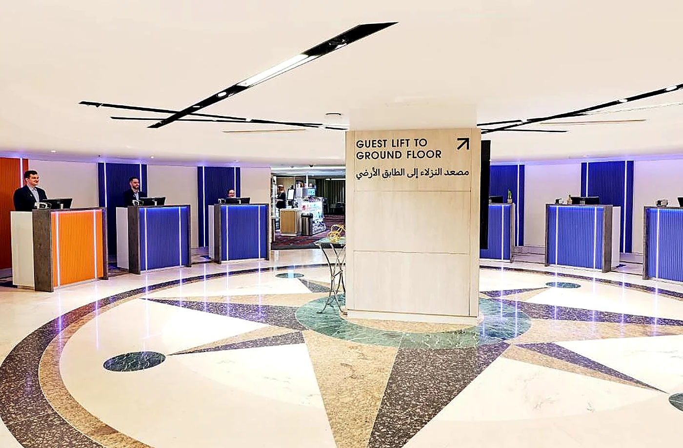 Circular hotel reception with multiple desks and statement flooring