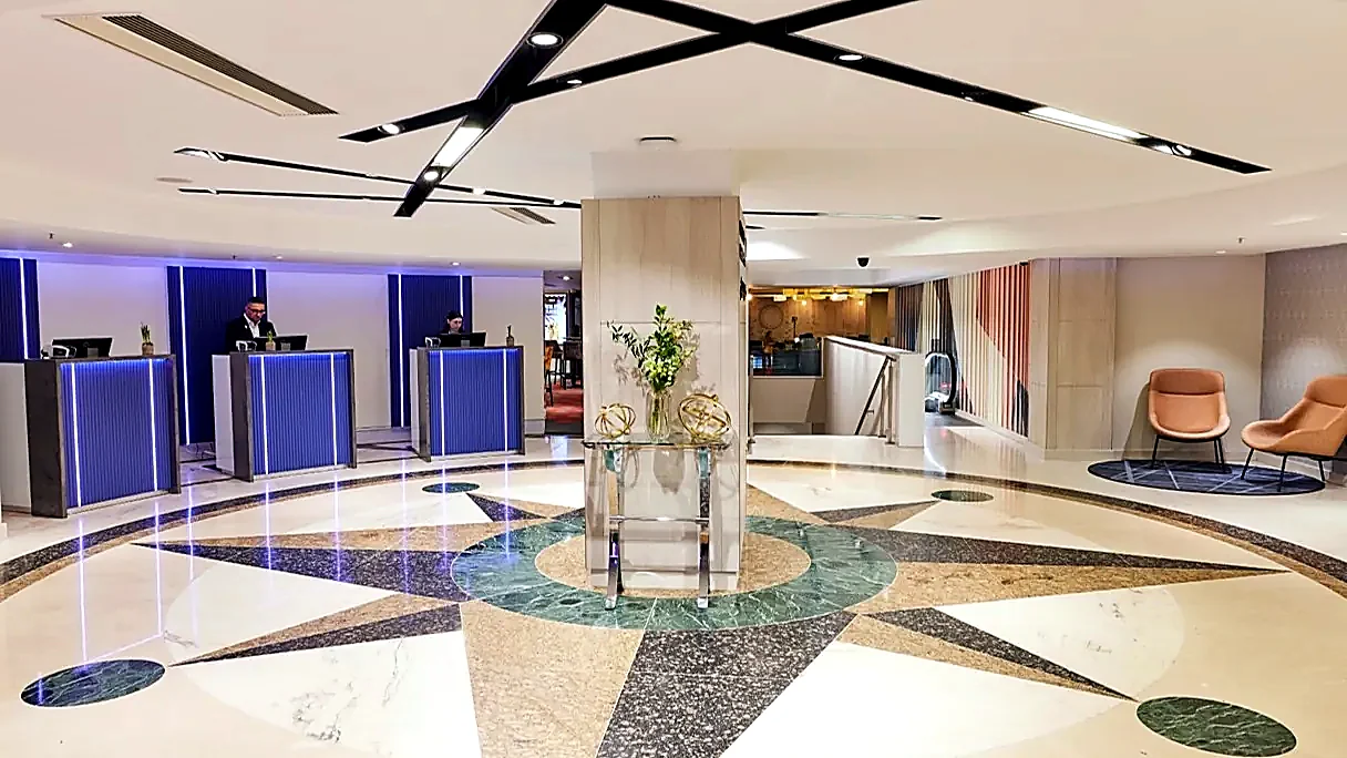 Hotel reception area with feature lighting, escalator and staircase