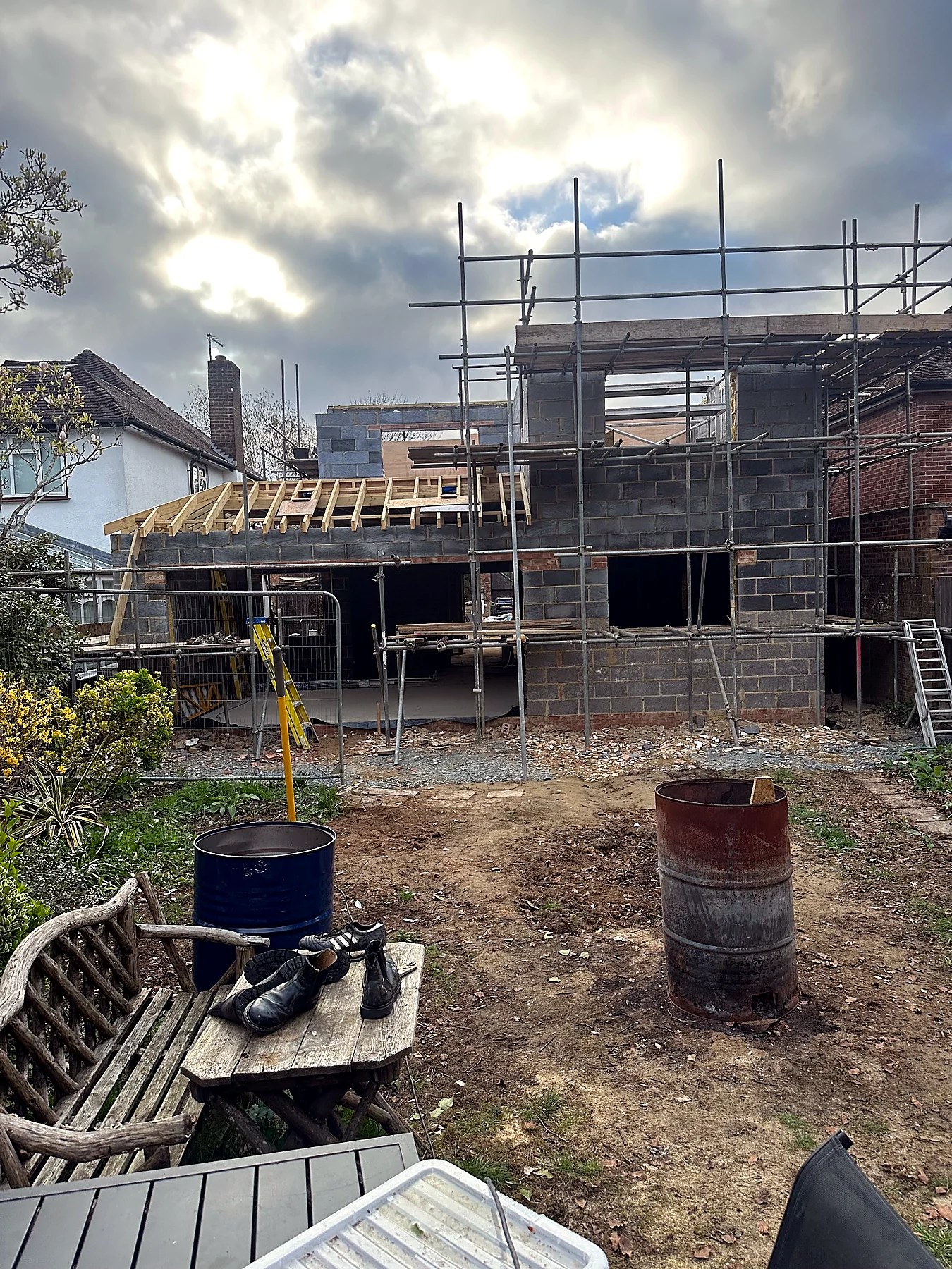 Rear residential extension under construction with masonry shell and scaffold
